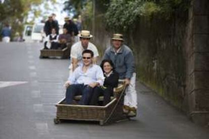 Turistas a bordo de los cestos de los 'Carreiros do Monte', en Funchal (Madeira).