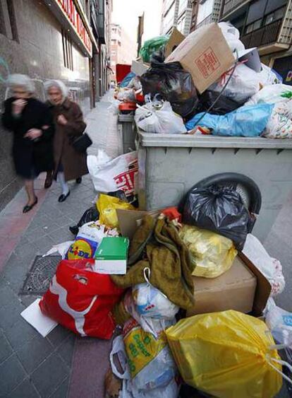 La basura se acumula en varios contenedores de una calle de Carabanchel.