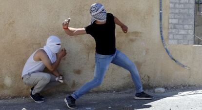 Un joven palestino tira piedras a las fuerzas israelíes en Jerusalén.