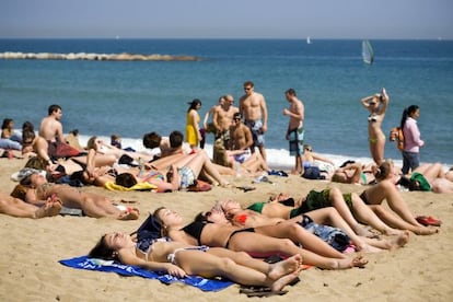 Ba&ntilde;istas en la playa de la Barceloneta de Barcelona.