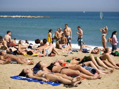 Ba&ntilde;istas en la playa de la Barceloneta de Barcelona.