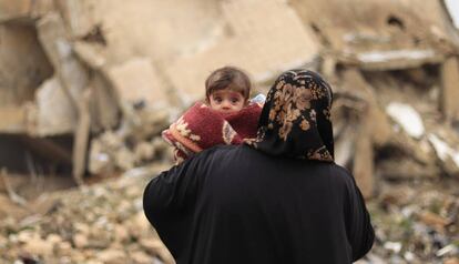 Una madre pasea con su bebé en brazos por las calles de Alepo el pasado mes de enero.