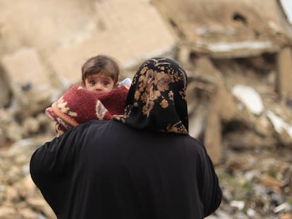 Una madre pasea con su bebé en brazos por las calles de Alepo el pasado mes de enero.