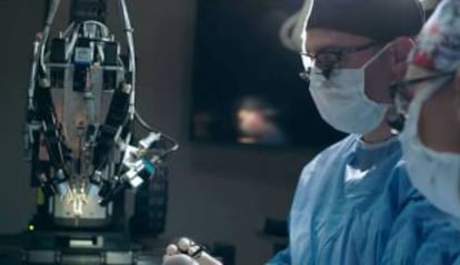 Dos investigadores en una captura de un vídeo promocional de Neuralink, mientras implantan uno de los chips.