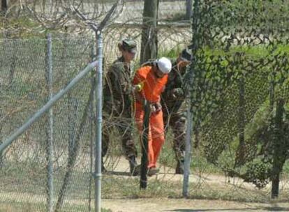 Un detenido es trasladado por dos soldados para ser interrogado en el campo de detención de EE UU en Guantánamo.