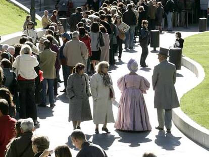 Dos figurantes vestidos de época pasean entre las personas que hacen cola para visitar las nuevas instalaciones del Museo del Prado, estrenadas ayer.