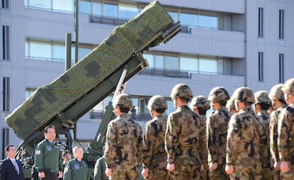 El primer ministro japonés da un discurso ante una batería antiaérea.