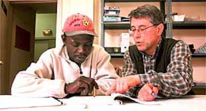 Un profesor atiende a un alumno africano en la escuela de adultos de Salt (Gironès).