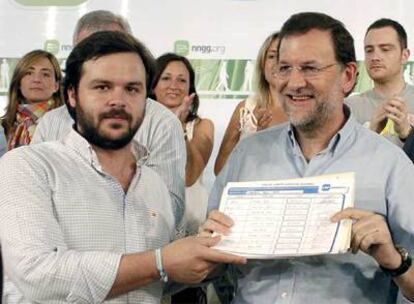 El líder popular, Mariano Rajoy, y el presidente de Nuevas Generaciones, Ignacio Uriarte, muestran los 114 avales de los jóvenes del PP.