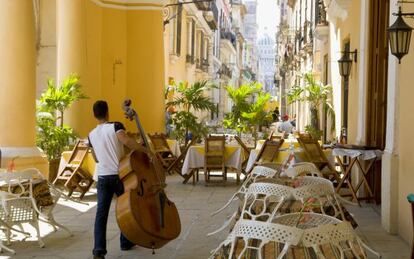 Un m&uacute;sico, con su contrabajo, en los soportales de La Habana Vieja.