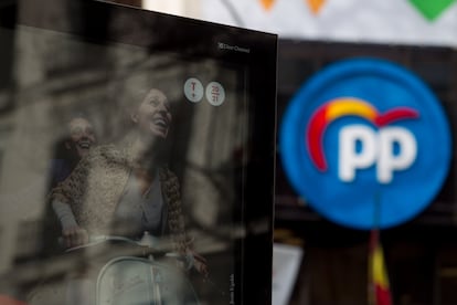 Cartel promocional, en primer término, de una obra del Teatro Español. Al fondo, la sede del Partido Popular en la calle Génova de Madrid.