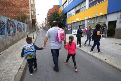 Un pare recull els seus fills de l'escola Bisbat de Terrassa, tancada per la vaga.