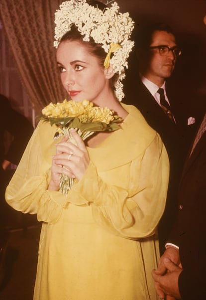 La actriz Elizabeth Taylor durante su primera boda con Richard Burton en 1964. La actriz llevaba un vestido amarillo de Irene Sharaff y el pelo recogido con jacintos y lirios del valle.
