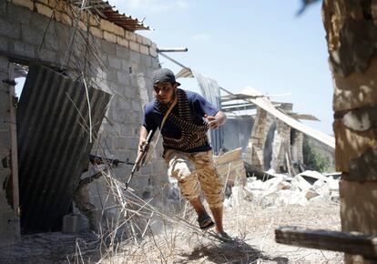 Un combatiente progubernamental corre en busca de cubierta en la batalla de Sirte