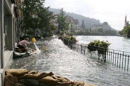 Una mujer lucha contra la crecida del río Aare en la ciudad de Thun, en la región suiza de Berner Oberland.