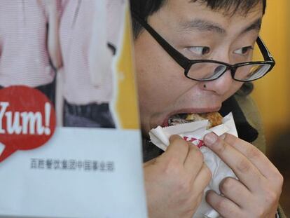 Un hombre consume pollo frito en una cadena de comida r&aacute;pida en Shanghai.