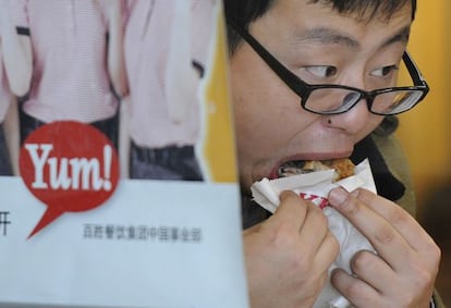 Un hombre consume pollo frito en una cadena de comida rápida en Shanghai.