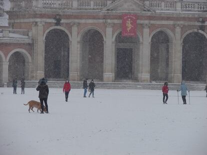 Varios ciudadanos pasean bajo una intensa nevada en la localidad madrileña de Aranjuez el pasado jueves.