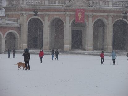 Varios ciudadanos pasean bajo una intensa nevada en la localidad madrileña de Aranjuez el pasado jueves. 