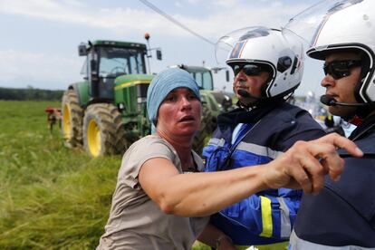 Una manifestante se enfrenta a gendarmes franceses durante la decimosexta etapa de la carrera ciclista Tour de Francia. 