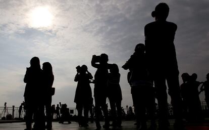Un grupo de personas observa el cielo en el instante en que se produce un eclipse anular de sol hoy, lunes 21 de mayo de 2012, en Tokio (Japón). El eclipse fue visible desde China hasta Texas (EE.UU)