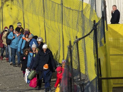 Refugiados caminan a lo largo de una valla instalada en la frontera con Eslovenia, en Spielfeld, Austria.