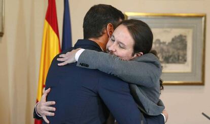 Pedro Sánchez y Pablo Iglesias se abrazan en el Congreso tras la firma del preacuerdo, este martes.