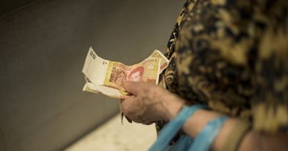 Una mujer sostiene pesos argentinos el pasado mi&eacute;rcoles. 