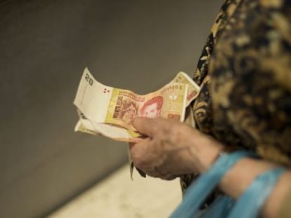 Una mujer sostiene pesos argentinos el pasado mi&eacute;rcoles. 