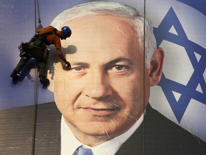 Un trabajador coloca en Tel Aviv un cartel de la campaña electoral de Netanyahu.