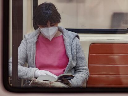 Una pasajera lee un libro en un vagón del Metro de Madrid.