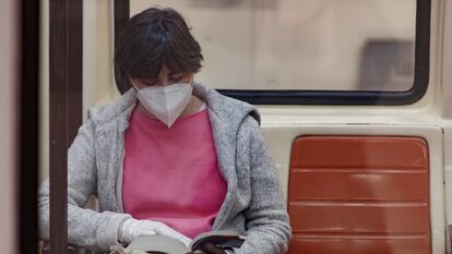 Una pasajera lee un libro en un vagón del Metro de Madrid.