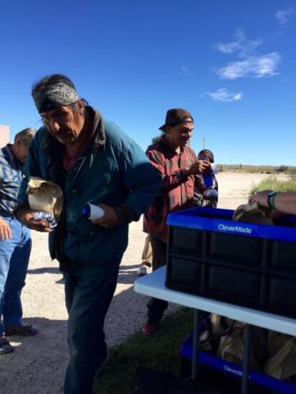 Louis y otro sioux cogen comida gratis de la organización de cristianos.