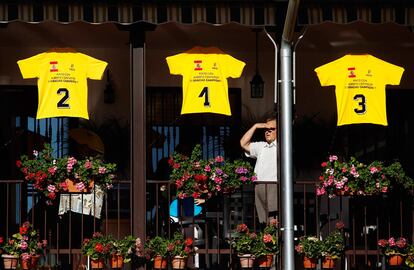 Un hombre espera la llegada de Alberto Contador a la localidad de Pinto, en un balcón decorado con tres maillot amarillos en referencia a las victorias logradas en la ronda francesa.