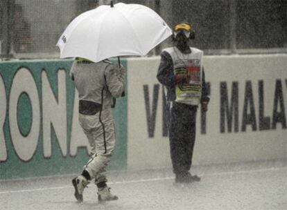 Button camina bajo el diluvio cuando se suspendió la carrera.