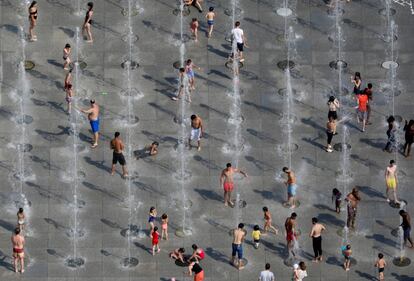 La gente se refresca en las fuentes del Parc André-Citroën, en París, durante la ola de calor.