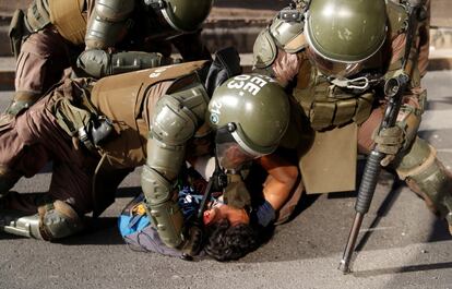 Un policía golpea a un manifestante detenido durante una protesta contra el gobierno de Chile en Santiago.