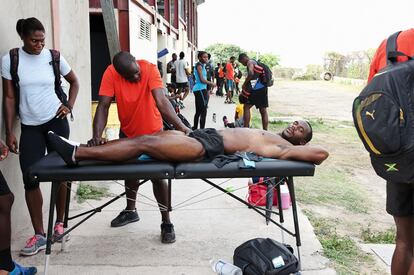 Nesta Carter, doble campeón olímpico de relevos de 4x100 metros, tumbado sobre una camilla de estiramientos al terminar su entrenamiento en la pista aledaña al estadio nacional de Kingston.