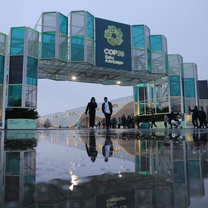 BAKU, AZERBAIJAN - NOVEMBER 18: Conference participants arrive at the main gate reflected in a puddle on day seven of the UNFCCC COP29 Climate Conference on November 18, 2024 in Baku, Azerbaijan. The COP29, which is running from November 11 through 22, is bringing together stakeholders, including international heads of state and other leaders, scientists, environmentalists, indigenous peoples representatives, activists and others to discuss and agree on the implementation of global measures towards mitigating the effects of climate change. According to the United Nations, countries made no progress over the last year in reducing global emissions from the burning of fossil fuels. (Photo by Sean Gallup/Getty Images)