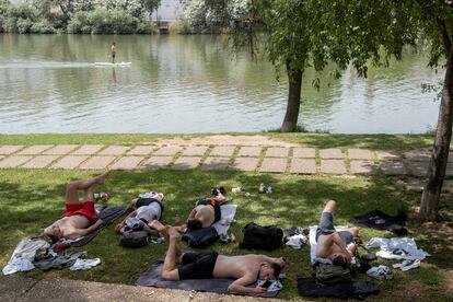 Aficionados del Eintracht Fráncfort descansaban el jueves a la sombra junto al río en Sevilla. 
