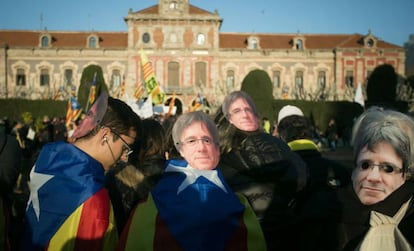 Manifestantes independentistas con caretas de Puigdemont han marchado en apoyo a la investidura del candidato.