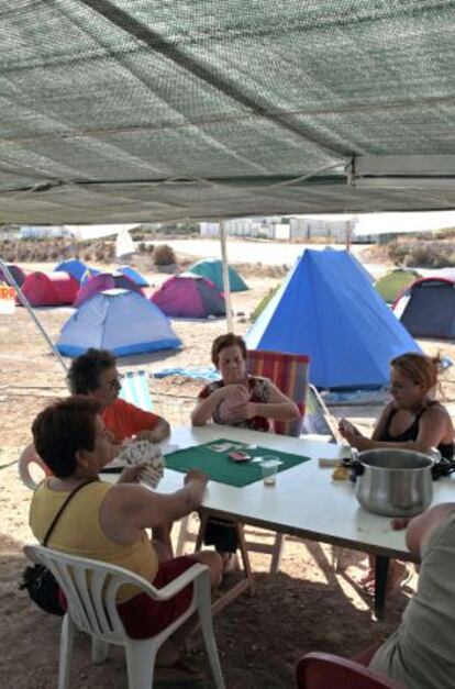 Varias mujeres juegan una partida de cartas en la acampada contra el vertedero.