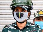 Security personnel wearing facemasks stand guard on the streets in Shaheen Bagh area after removing demonstrators continuously protesting against a new citizenship law, while the government imposed a lockdown as a preventive measure against the COVID-19 novel coronavirus in New Delhi on March 24, 2020. (Photo by Sajjad  HUSSAIN / AFP)