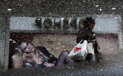 A shopper is reflected next to the window of a clothing store in a puddle of water downtown Madrid January 19, 2010. Picture has been rotated 180 degrees.   REUTERS/Susana Vera/File Photo     GLOBAL BUSINESS WEEK AHEAD PACKAGE - SEARCH 'BUSINESS WEEK AHEAD 28 NOV'  FOR ALL IMAGES