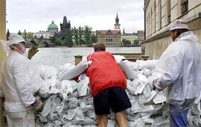 Voluntarios trabajan para crear muros de contención en el casco histórico de Praga.