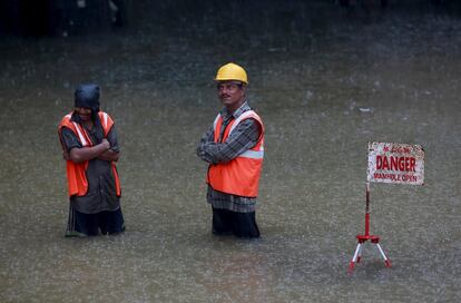 Al menos 13 personas han muerto y miles se han visto afectadas por lluvias torrenciales y deslizamientos de tierra asociados a la temporada de monzones en el estado indio de Meghalaya, en el noreste del país. En la imagen, trabajadores indios esperan bajo la lluvia en una carretera inundada en Bombay.