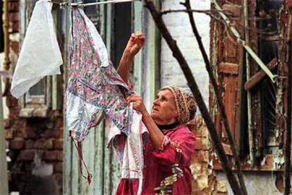 Una mujer tiende ropa junto a su casa en ruinas en Krasnodar, en el sur de la Federación Rusa.
