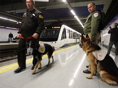 Dos guardias de seguridad, con los perros de la unidad de vigilancia canina del metro de Madrid.