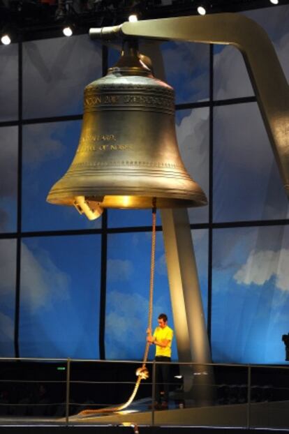 Wiggins, vestido de amarillo como ganador del Tour, bajo una campana gigante.