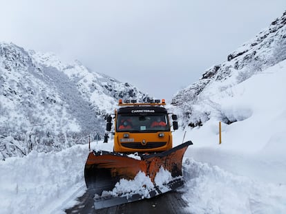 Dos operarios de una quitanieves trabajan en la carretera que accede al puerto de San Isidro, en Asturias.